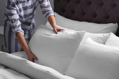 Woman fluffs the pillows